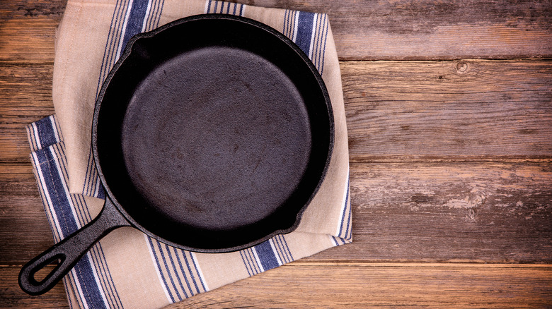 cast iron skillet on a dish towel on a wooden background