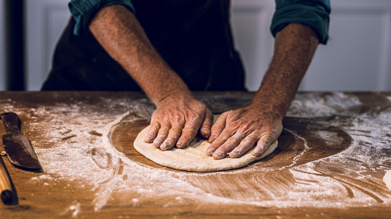 Person stretching pizza dough