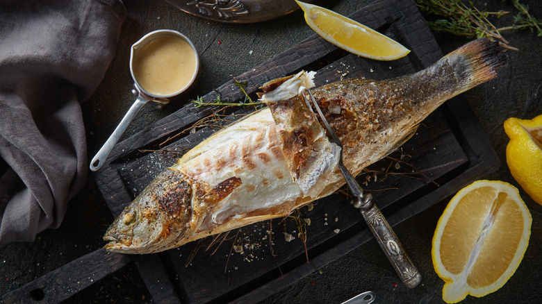 Whole fish with crispy skin being peeled back