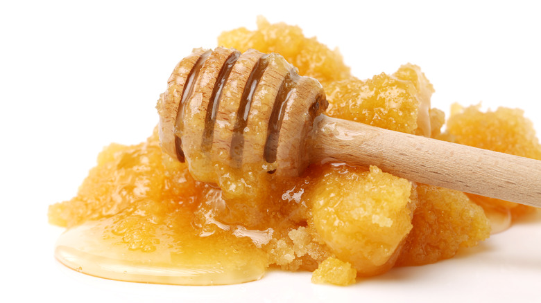 honey stick on top of pile of crystallized honey