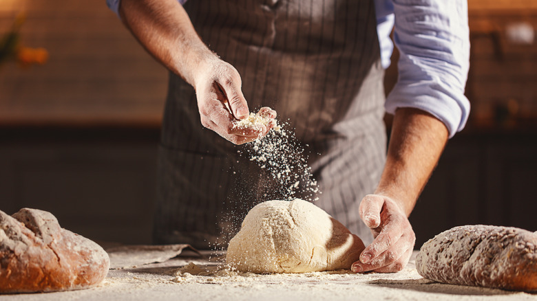 Baker flouring bread dough