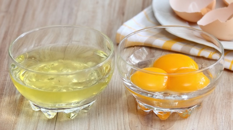 Separated egg yolks and whites in glass dishes