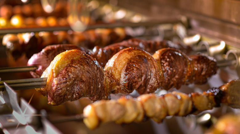 skewers of meat roasting on a grill