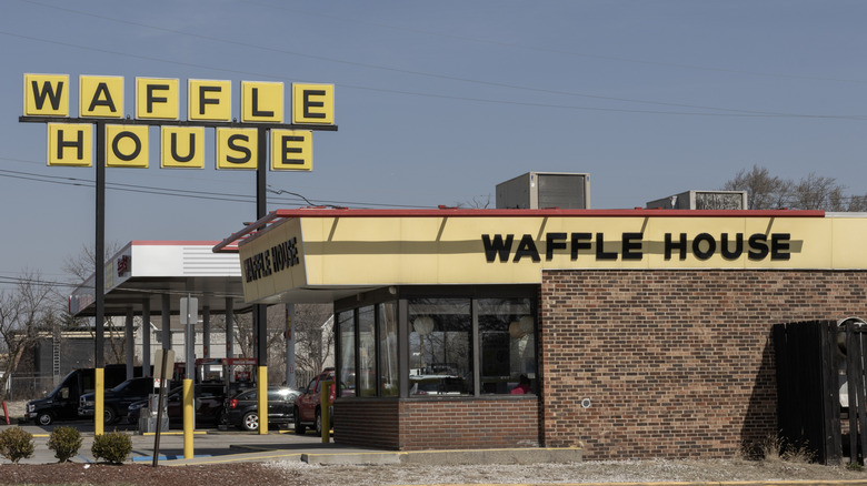 A Waffle House with signature yellow block sign seen from the road