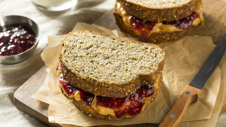 Two peanut butter & jelly sandwiches on a cutting board