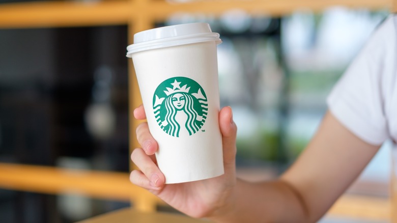 Starbucks barista holding grande drink