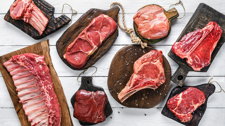 An assortment of different cuts of beef on wooden cutting boards