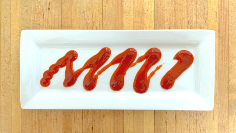 Drizzle of Open Pit Original BBQ Sauce on white rectangular plate