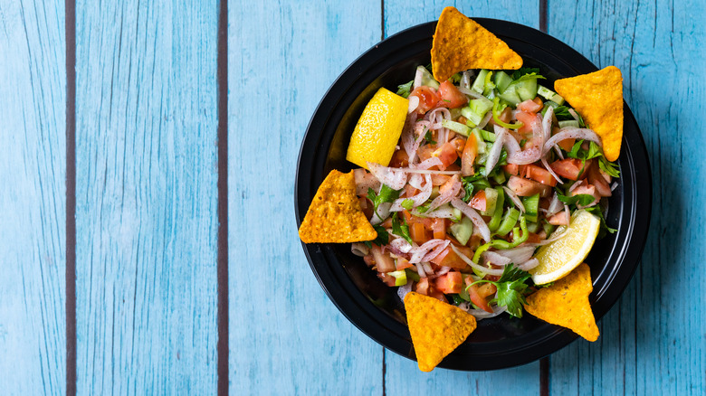 bowl of guacamole with toppings and tortilla chips