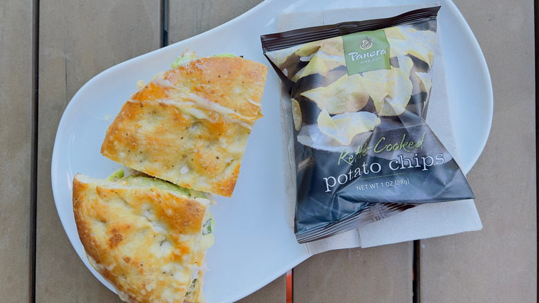 A panini sandwich and a bag of potato chips from Panera