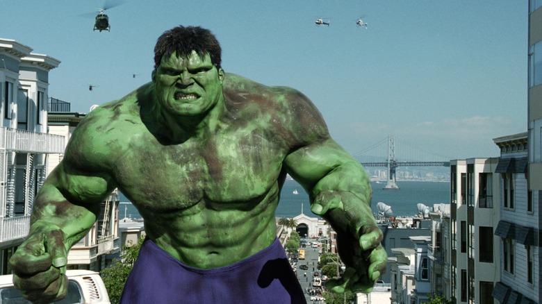 The Hulk covered in dust looking angry with helicopters advancing