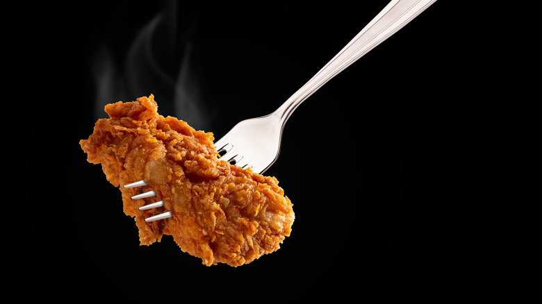Small piece of fried chicken pierced by a fork