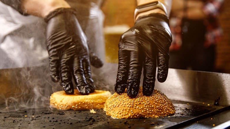 Chef toasting bun on a flat top
