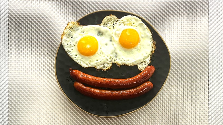 Fried eggs and sausages shaped like a smiley face