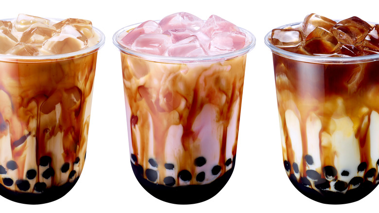 Two bubble tea with boba on wooden coasters