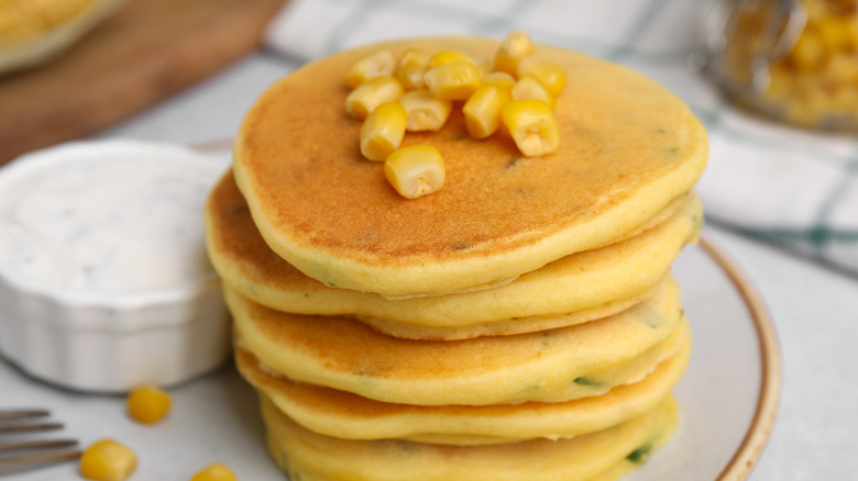 Stack of corn pancakes topped with corn kernels