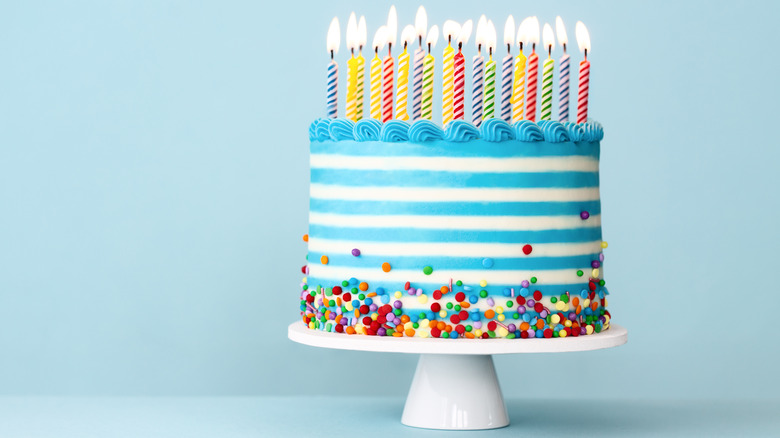 blue and white striped cake with candles