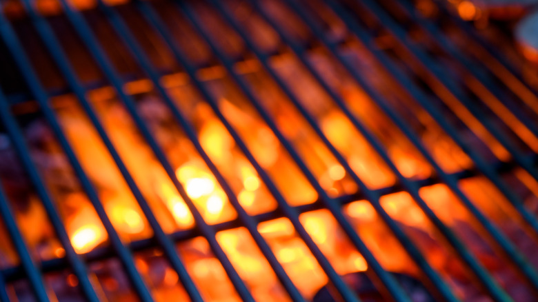Close up of a grill grate with fire beneath it