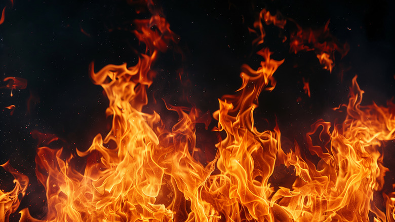 Bright yellow flames against a black background with sparks