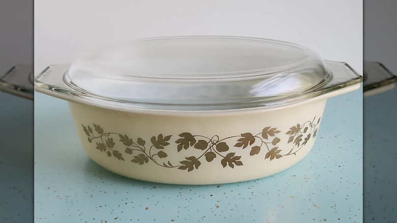 A vintage Pyrex dish with a golden leaf and acorn pattern