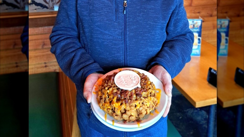 Person holding Texas Roadhouse cactus blossom covered in cheese