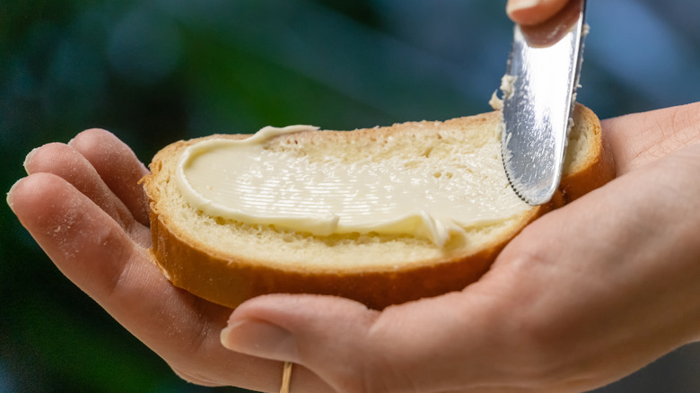 hand buttering toast 