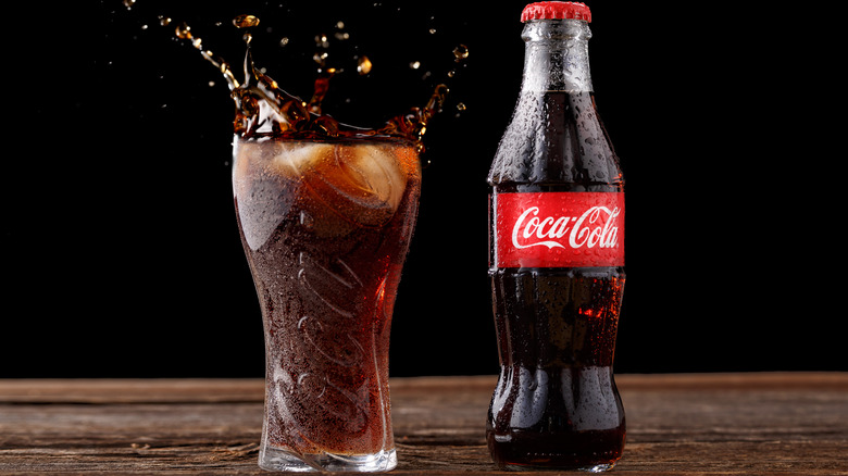 Bottle of Coca-Cola and glass of splashing cola