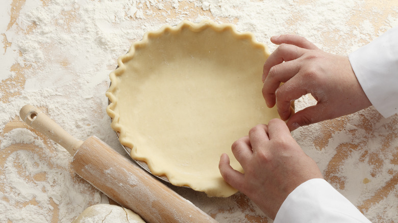 A chef shapes a pie crust