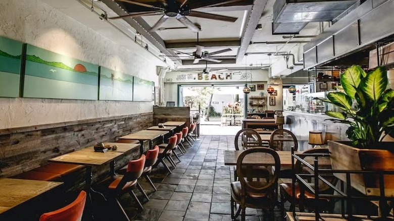 Interior of Heavenly Island Lifestyle with rows of tables and a stone floor