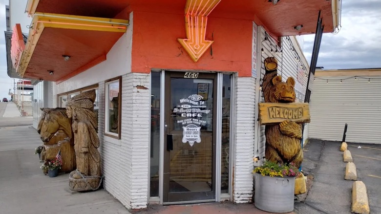 The door of North Hi-Way Cafe surrounded by carved wooden statues