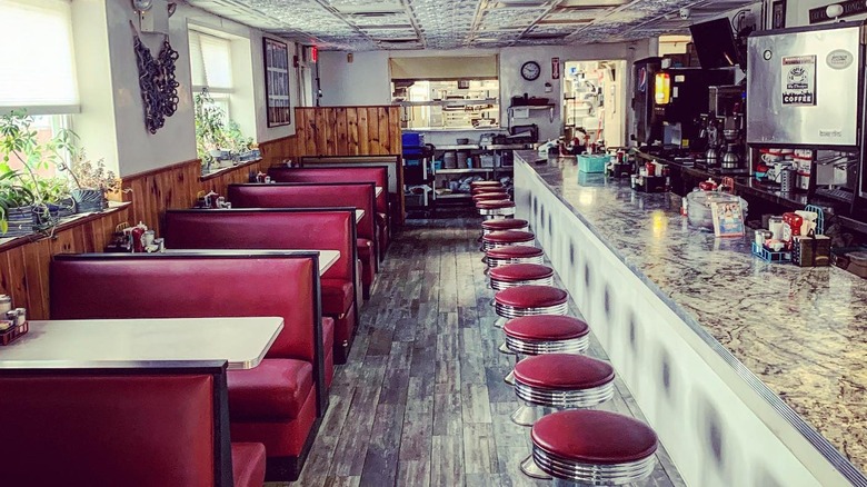 Interior of Becky's Diner with booths and stools at the counter