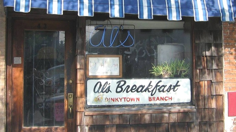 Exterior of Al's Breakfast in Dinkytown, with window signs and a blue awning
