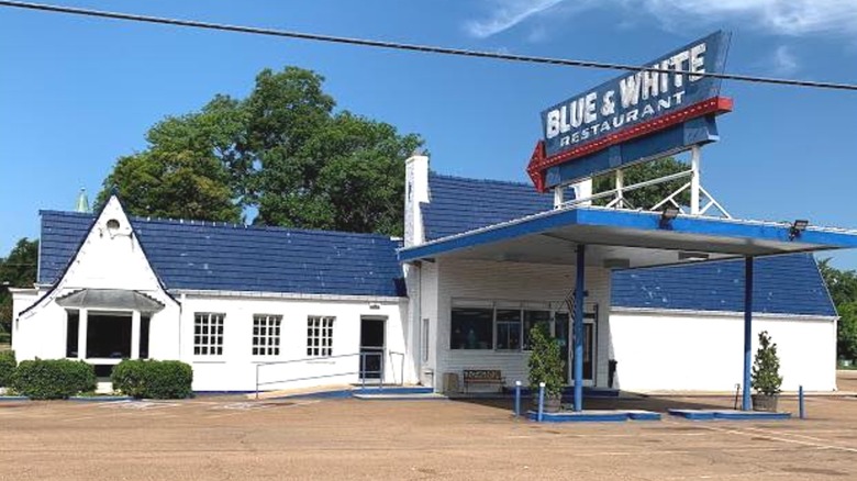 Exterior of Blue & White Restaurant with a large diner sign over a converted gas station