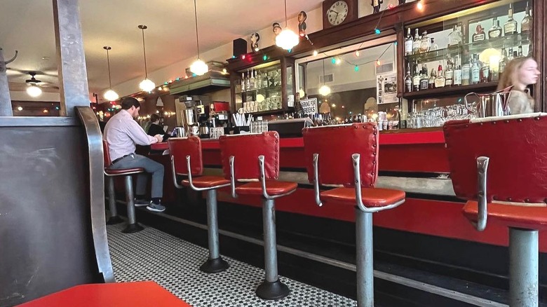 Interior of Mecca Restaurant, with red diner stools by the counter