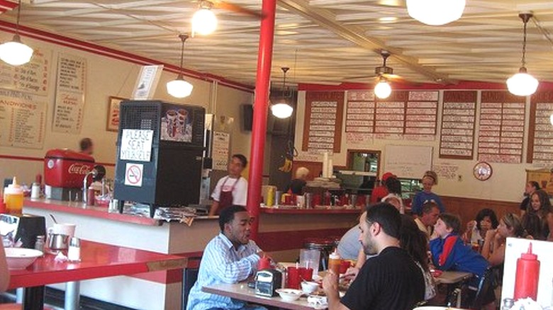 Busy interior of Mickie's Dairy Bar with whiteboard signs advertising the menu
