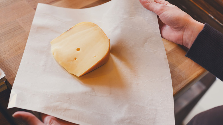 person wrapping cheese in paper