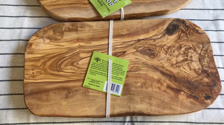 A Trader Joe's olive wood cutting board with distinctive grain patterns