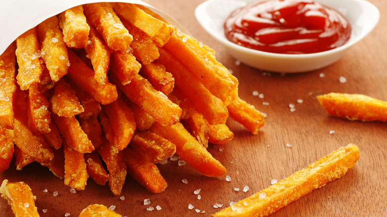 sweet potato fries next to saucer of ketchup