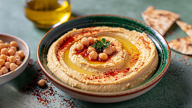 Bowl of hummus swirled with olive oil and paprika
