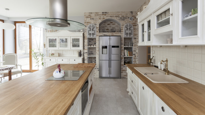 large, bright kitchen with stainless steel fridge and wooden countertops