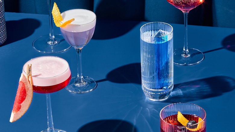 Five cocktails on a blue backdrop
