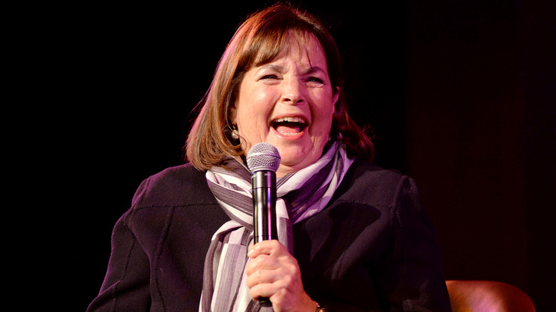 Ina Garten smiling while holding a microphone