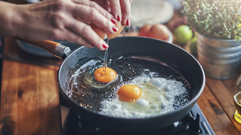 Cracking eggs into a pan