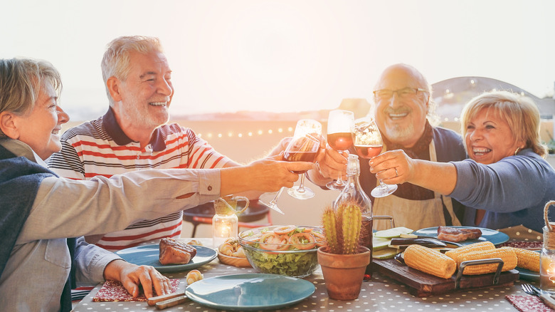 people clinking glasses at table