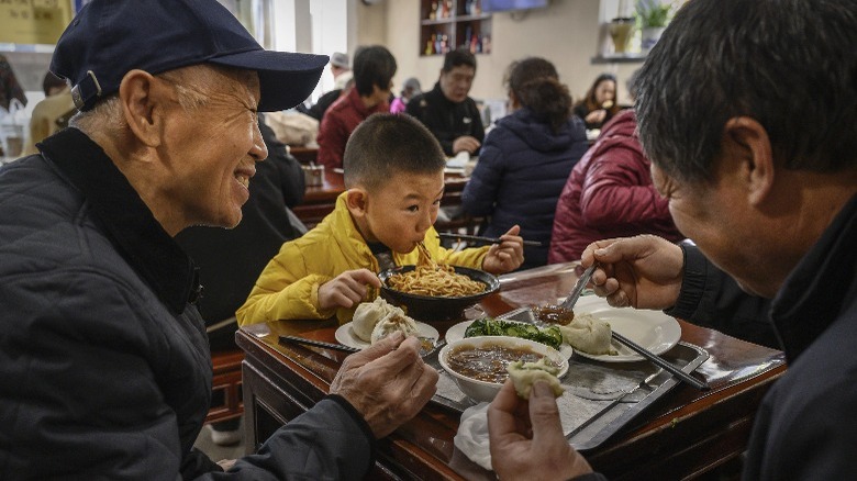Asian family eating noodles