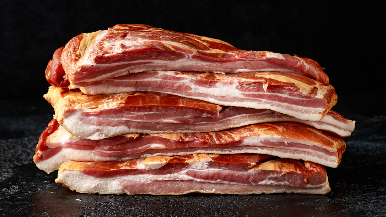 sliced bacon on a black background