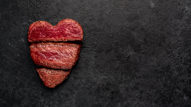 Three pieces of steak arranged into a heart shape, with extra-rare piece at the top