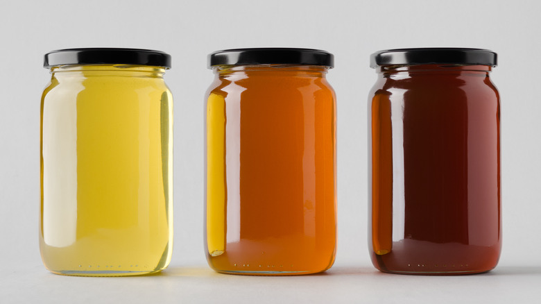 three different colored honey jars