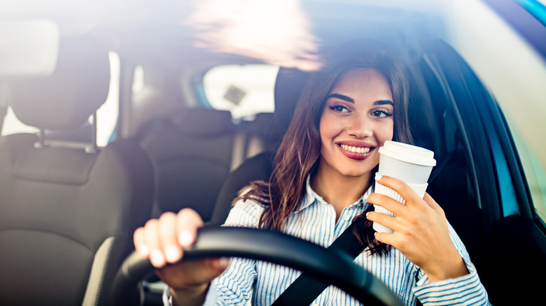 woman driving with to-go coffee