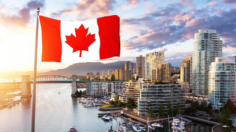 Canadian flag waving over city skyline